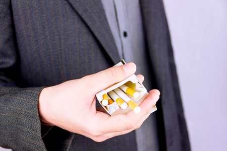 Close-up of man's hand holding a pack of cigarettesの写真素材