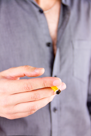 Close-up shooting of man holding a cigaretteの写真素材