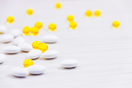 Hip of golden and white capsules isolated on white backgroundの写真素材