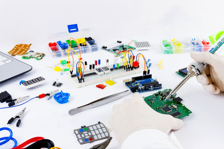 Microcontrollers, chips, resistors and light-emitting diodes on white desktop of hardware engineer