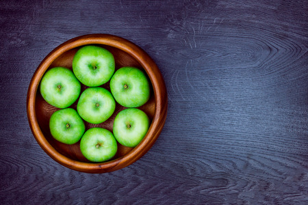 Healthy food. Several apples in the wooden plate isolated on grey background. Making apple pieの写真素材