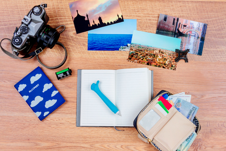  Top view of essentials for modern young person. Objects of a traveller isolated on wooden background: notebook with a pen, wallet with cash and cards, passport, film, camera,  photos of turkey, italy, france  and souvenirの写真素材