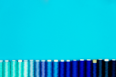 Set of colorful sewing spools isolated on blue background