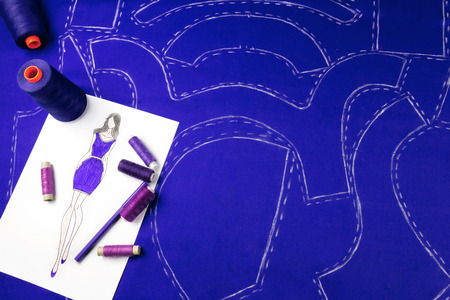 Workplace of a dressmaker:  pattern, textile, sewing spools, sketch and pencil.の写真素材