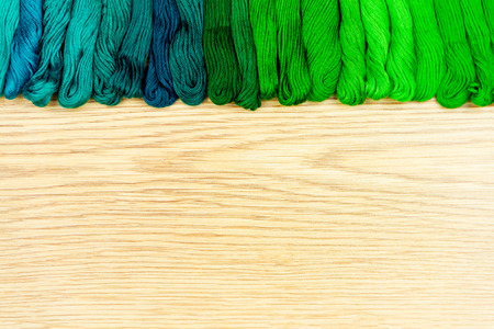 Palette of sewing threads isolated on wooden background.の写真素材