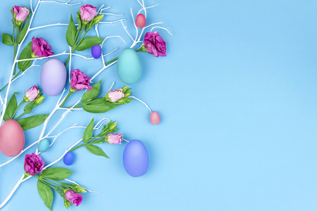 Happy Easter concept. Blue branch tree with colorful spring's flowers and colorful easter eggs on...