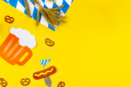 October fest concept. Wheat, germany beer, sweet tasty snacks pretzels and fork with sausage with mustard on yellow background.  Ads event of october beer festival in autumn october month. Beer dayの写真素材