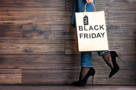 Customer buyer legs of woman female adult with shopping bag with sale label and black high heels...