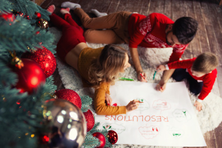 Happy Family: father, mother and son writing future resolutions and plans of family in coming 2019...