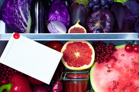 Fresh organic healthy raw antioxidant violet, red, food, vegetables, fruits and juices in vegan vegetarian fridge: fig,  watermelon, cabbage, onion, pepper, eggplant, tomato juice and space for text.の写真素材