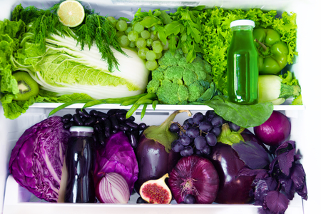 Summer fresh organic healthy raw antioxidant green and violet food, vegetables, fruits and juices in vegan vegetarian in opened full fridge of vitamins. Healthy eating, diet and lifestyle concept.の写真素材