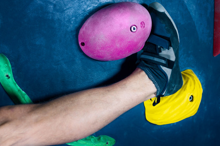 Leg of successful happy muscle healthy winner climber mountaineer alpinist man male climbing training in climbing wall in complex bouldering competition. Success and healthy lifestyle conceptの写真素材