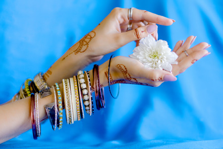 Slender elegant female wrists painted with traditional Indian oriental mehndi ornaments by henna....