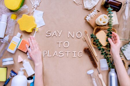 Bath accessories and personal care products on craft paper background. On left side items in disposable package, on right reusable natural. Female hands make choice. Say no to plastic. Zero waste.の写真素材