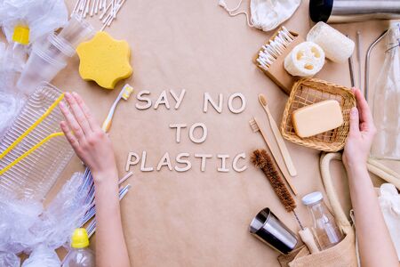 Bath accessories, care products, kitchenware, daily use subjects on craft paper background. On left side items in disposable package, on right reusable natural. Say no to plastic. Zero waste concept.の写真素材
