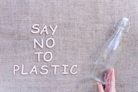 Reusable recyclable sustainable transparent glass bottle for water or oil isolated on brown craft fabric background. Refuse, reduce, recycle and zero waste concept. Ecology, safe nature and planet.の写真素材