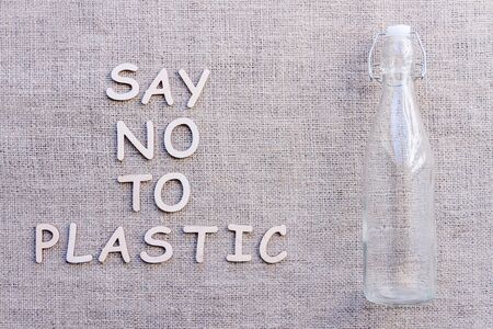 Reusable recyclable sustainable transparent glass bottle for water or oil isolated on brown craft fabric background. Refuse, reduce, recycle and zero waste concept. Ecology, safe nature and planet.の写真素材