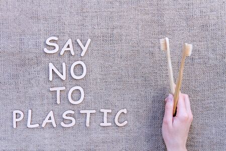 Reusable recyclable sustainable wooden toothbrushes isolated on brown crafted background. Refuse poly plastic tooth brushes waste. Refuse, reduce, recycle and zero waste concept. Ecology, safe nature.の写真素材