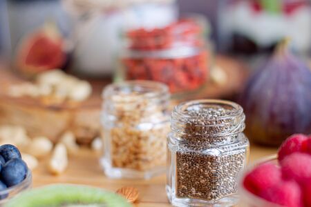 Closeup glass jar with chia seeds on background defocus. Light summer natural breakfast with dairy products, nuts, fruits and berries. Fitness diet nutrition. Healthy life and food concept.の写真素材