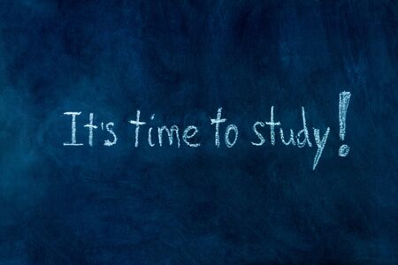 White chalk handwritten inscription of it is time to study in center of blackboard background. Preparing pupils children students for university, college, academy. Autumn mood concept.の写真素材
