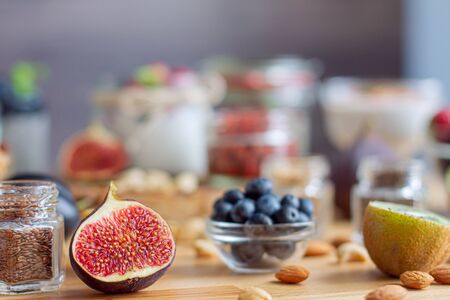 Closeup glass jar with chia seeds and 
figs on background bokeh. Light summer natural breakfast with dairy products, nuts, fruits and berries. Fitness diet nutrition. Healthy life and food concept.の写真素材