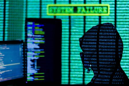 Man in hood and mask is hacking password. Programmer is writing code on multiple screens to steal...