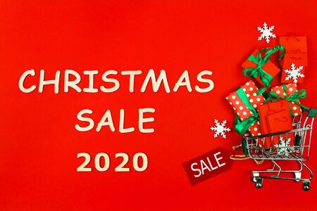Small trolley, mini shopping cart full of presents and packages. Gift boxes are packed in decorative...