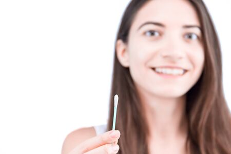 Young smiling woman is holding in hand disposable cotton bud, swab, stick. Girl is going to clean...