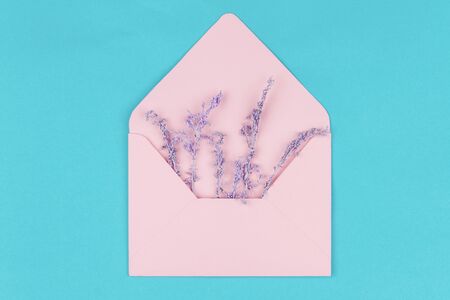 Pink envelope with small sprigs, flowers on blue background. Template for greeting card, invitation...