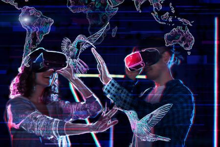 Girl and boy are playing in virtual reality game club. Young woman and man in VR glasses are gaming...