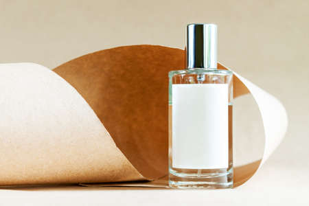 Closeup glass bottle of aromatic niche floral luxury perfume on abstract background of craft paper. Cosmetics, products for personal care and concept. Minimalistic packing, branding.の写真素材