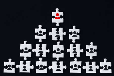 White gray puzzles with depicted female sign are stacked in pyramid on black background. One piece...