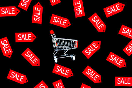 Little shopping cart in center of background canvas. Red label tags are scattered around. Black...