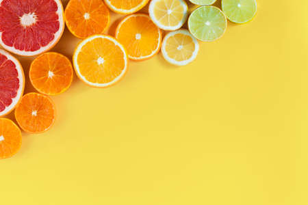 Slices of citruses are laid out in gradient composition in upper left corner of background....
