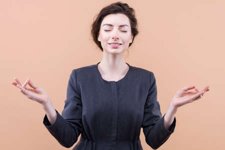 Beautiful business lady is meditating, relaxing, have break. Young woman girl in casual suit keep...