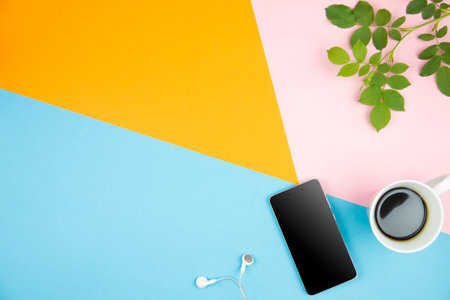 Flat lay design of office desk mock up with smartphone, cup of coffee on three tone orange, blue,...