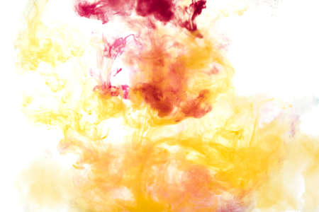 Bright pink and yellow acrylic paint swirling in water. Ink moving in liquid creating abstract clouds. Traces of colorful dissolving in water, changing shape. Abstract decorative creative background.の写真素材