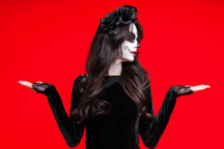 Girl with sugar skull makeup with a wreath of flowers on head, wear lace gloves, wide isolated on...