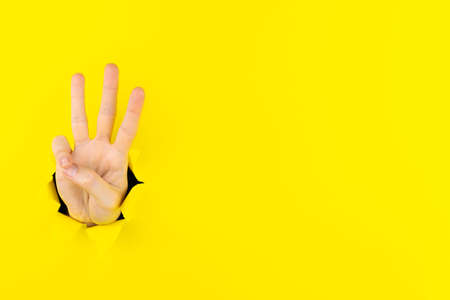 Woman hand showing number gesture isolated over pastel yellow background in studio. Copy space for advertisement. With place for text or image, promotional content. Advertising area, workspace mock up.の写真素材