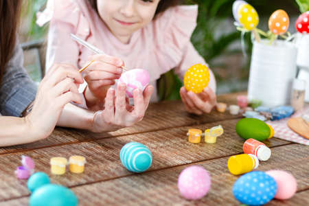 Happy Easter atmosphere! Close up funny, pretty, creative mom teacher, explain, to her cute, small,...
