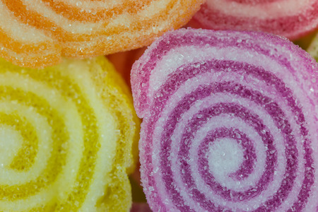 Gummy candies stretched on wood .