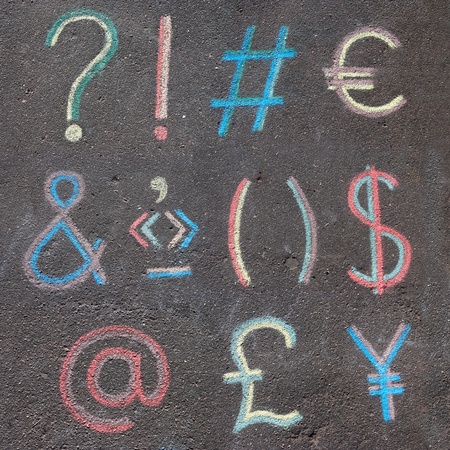 punctuation marks, mathematical symbols and currency symbols drawn on asphalt with chalkの写真素材