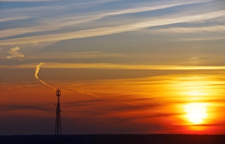 silhouette of mobile phone communication antenna tower on sunset sky backgroundの写真素材
