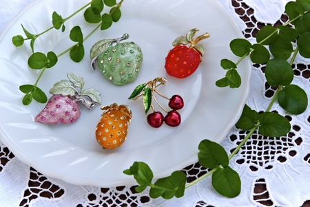 still life with jewelry fruits on white dishの写真素材