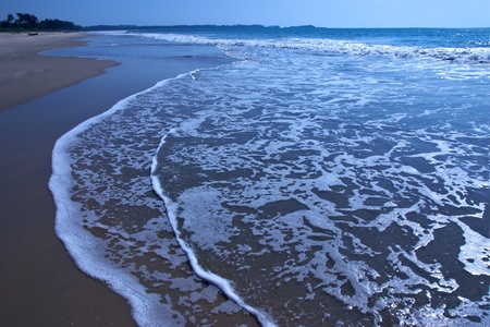 Sunny sandy beach covered with long surfの写真素材