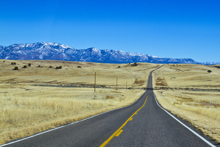 long empty asphalt road toward the mountains の写真素材