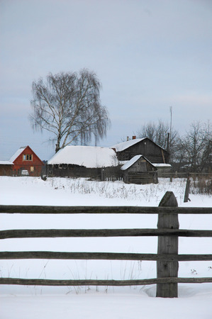 Old wooden fence in winter villageの写真素材