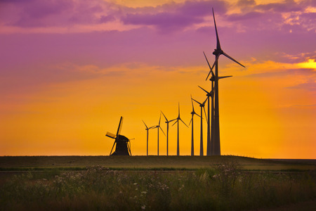 Windmills in front of bright sunset skyの写真素材