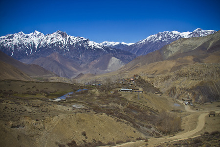Village in the valley surrounded snowy Himalayan peaksの写真素材