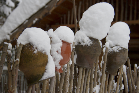 old wooden fence and ceramic jars in winterの写真素材